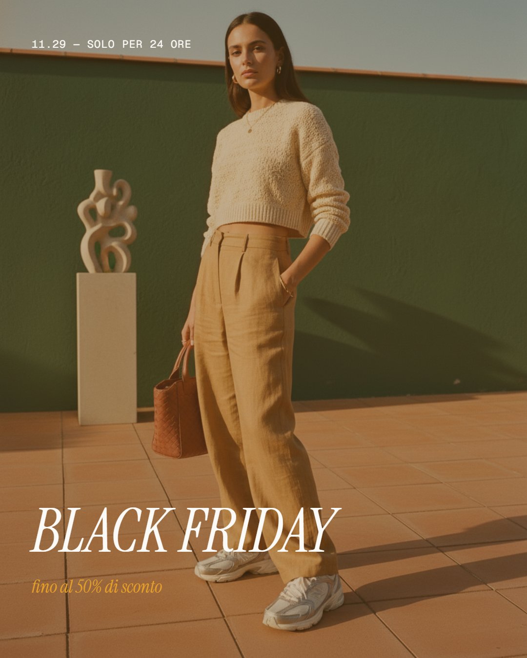 Sale card editoriale Black Friday con modella, maglione bianco, pantaloni cammello, borsa marrone, terrazza verde, claim 50%